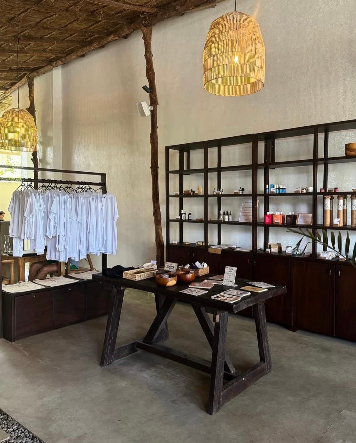 The shop corner with white tees and rattan lamps