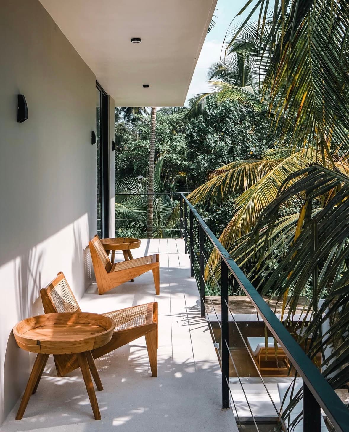 Villa balcony with rattan chairs overlooking the palms