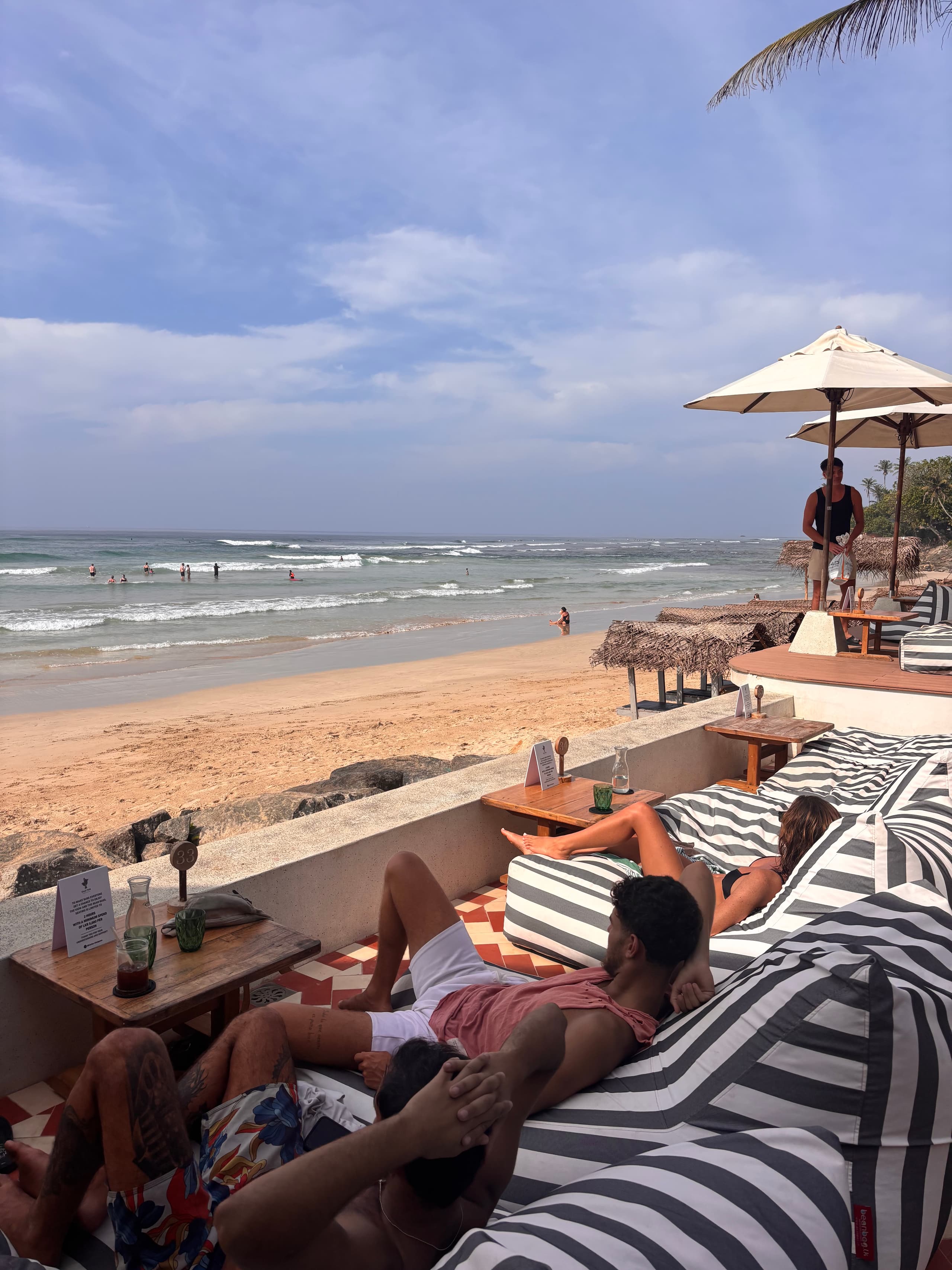 Striped bean bags on the terrace above the beach and surf