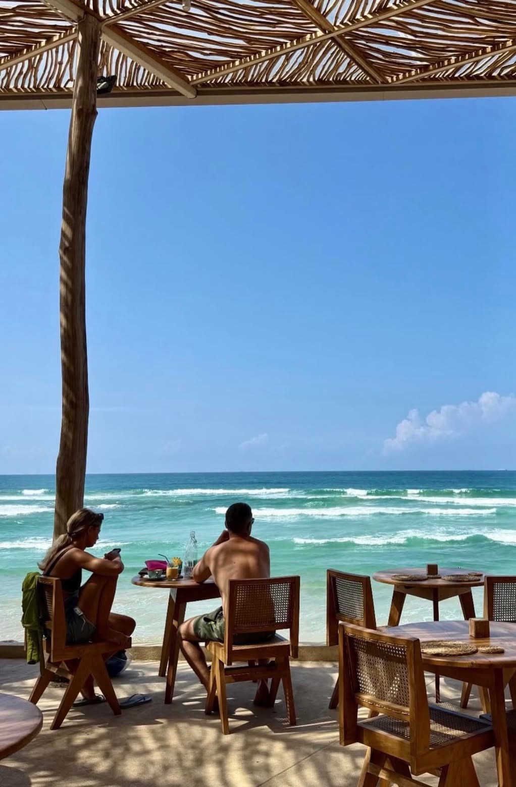 Rattan chairs on the terrace facing the waves