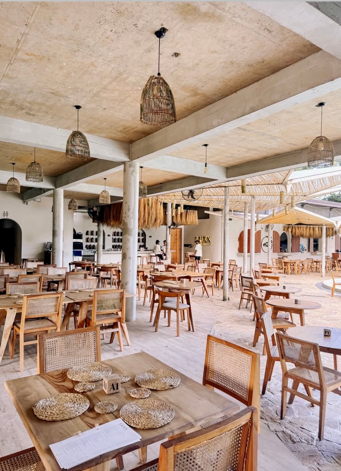 Restaurant hall with rattan chairs and woven pendant lamps