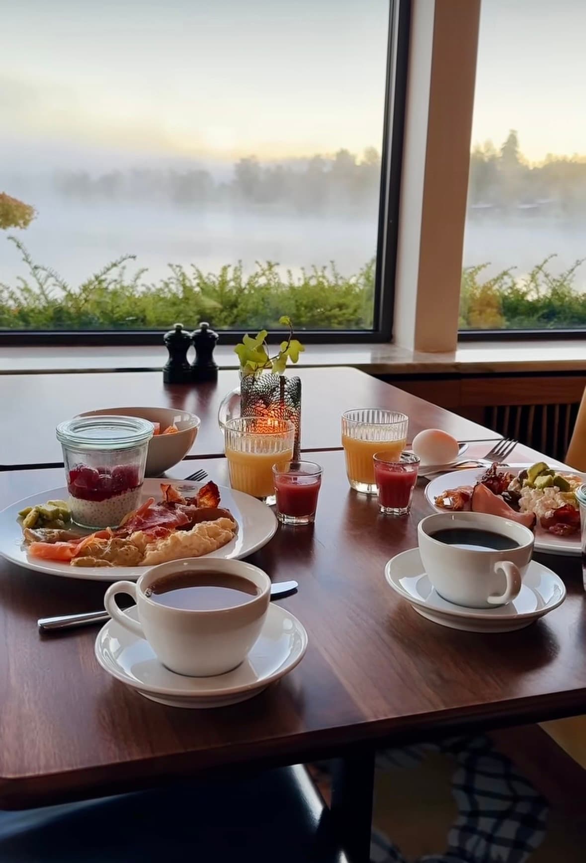 Breakfast table by the window with mist over the lake