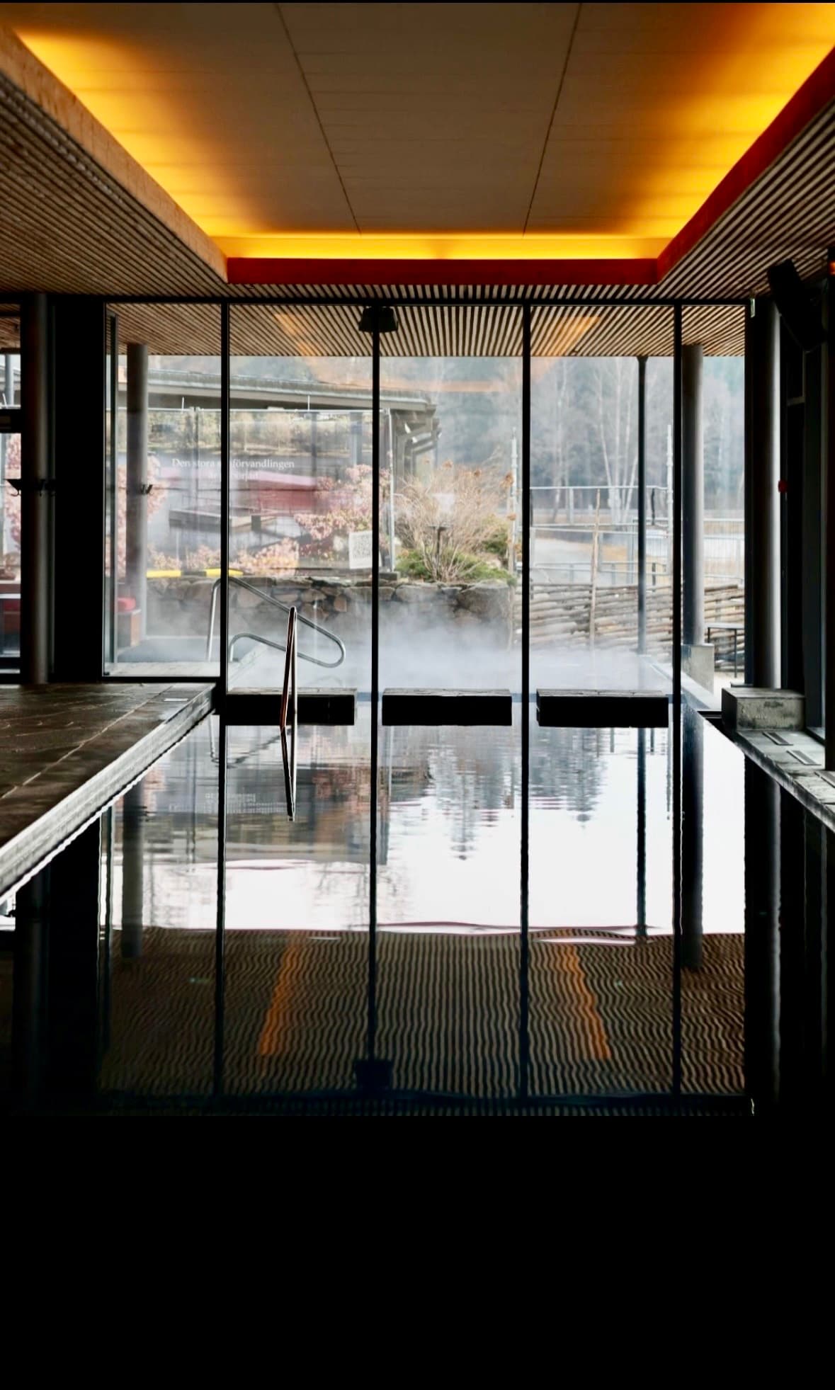 Steaming spa pool behind glass walls