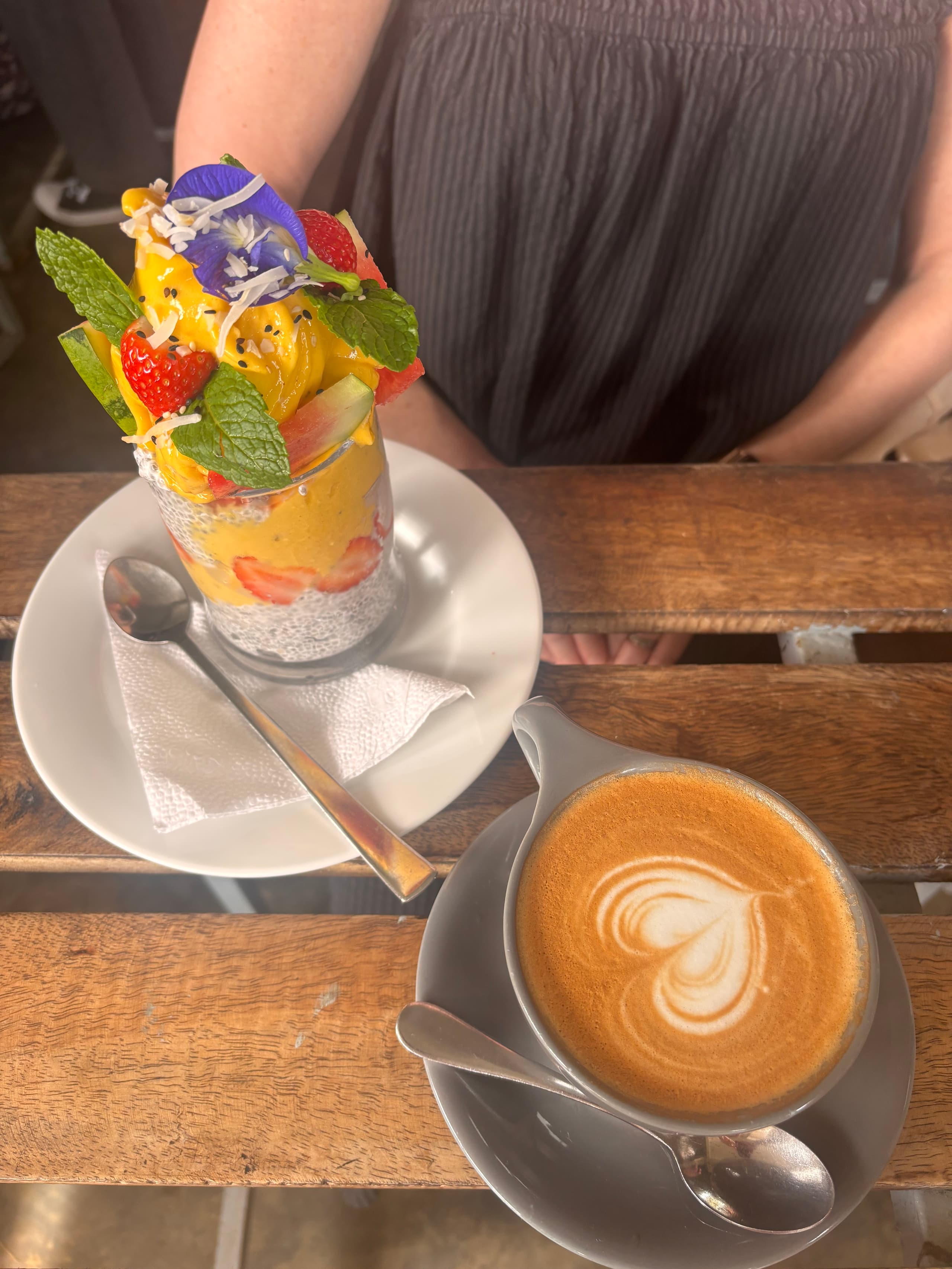 Mango chia pudding and a cappuccino on a wooden table