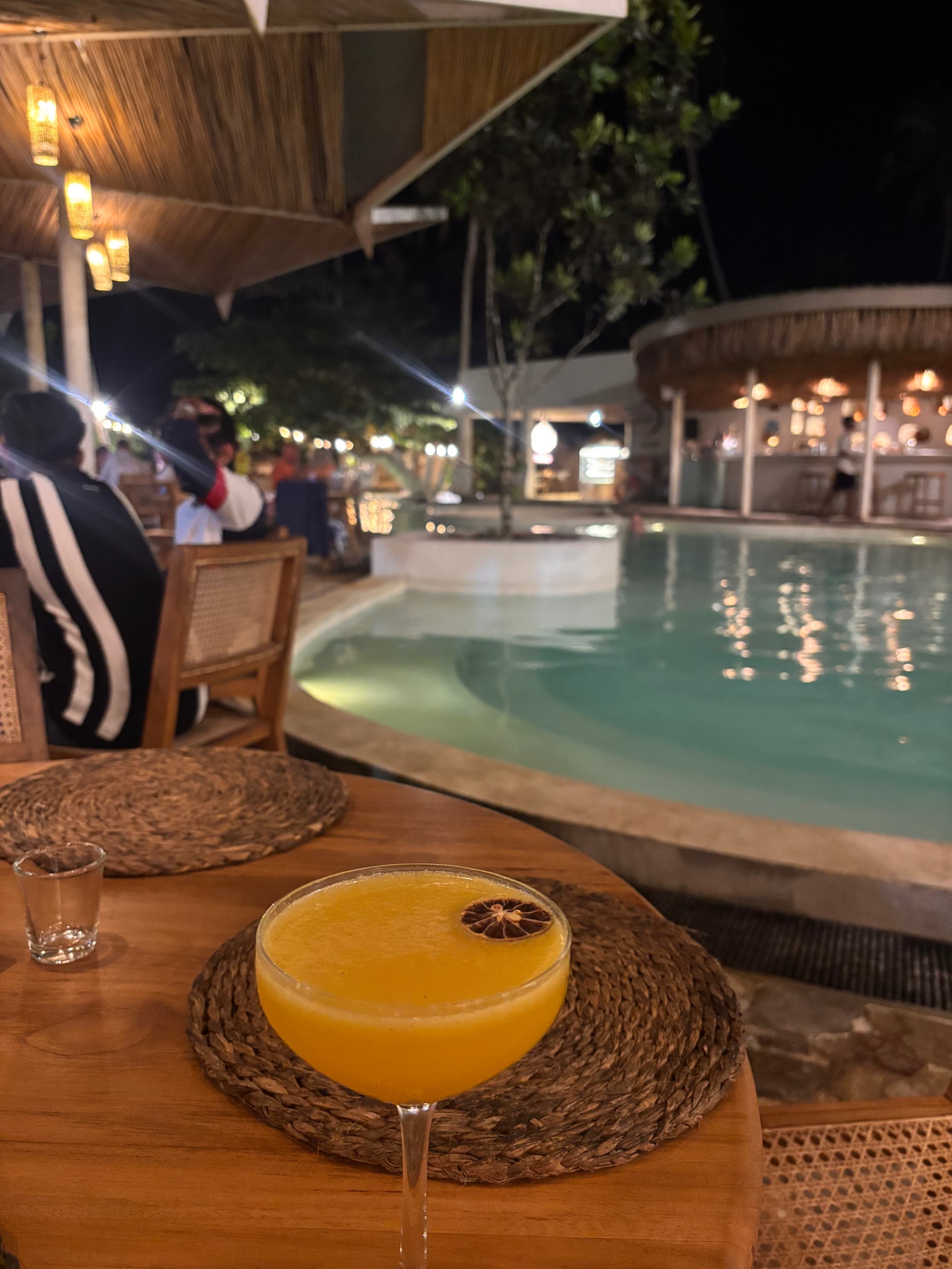 Cocktail by the lit-up pool at night