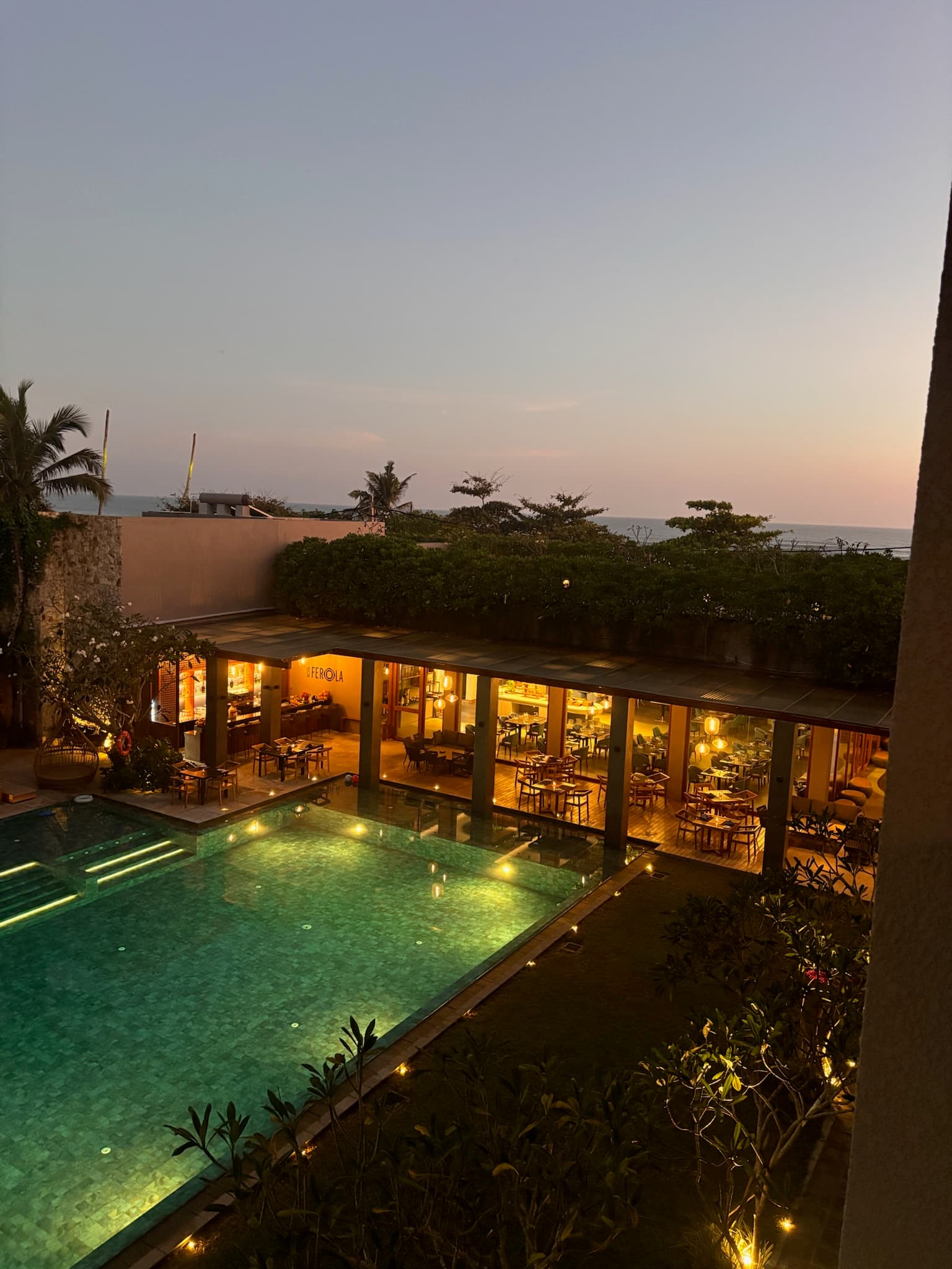 The pool and restaurant lit up at dusk