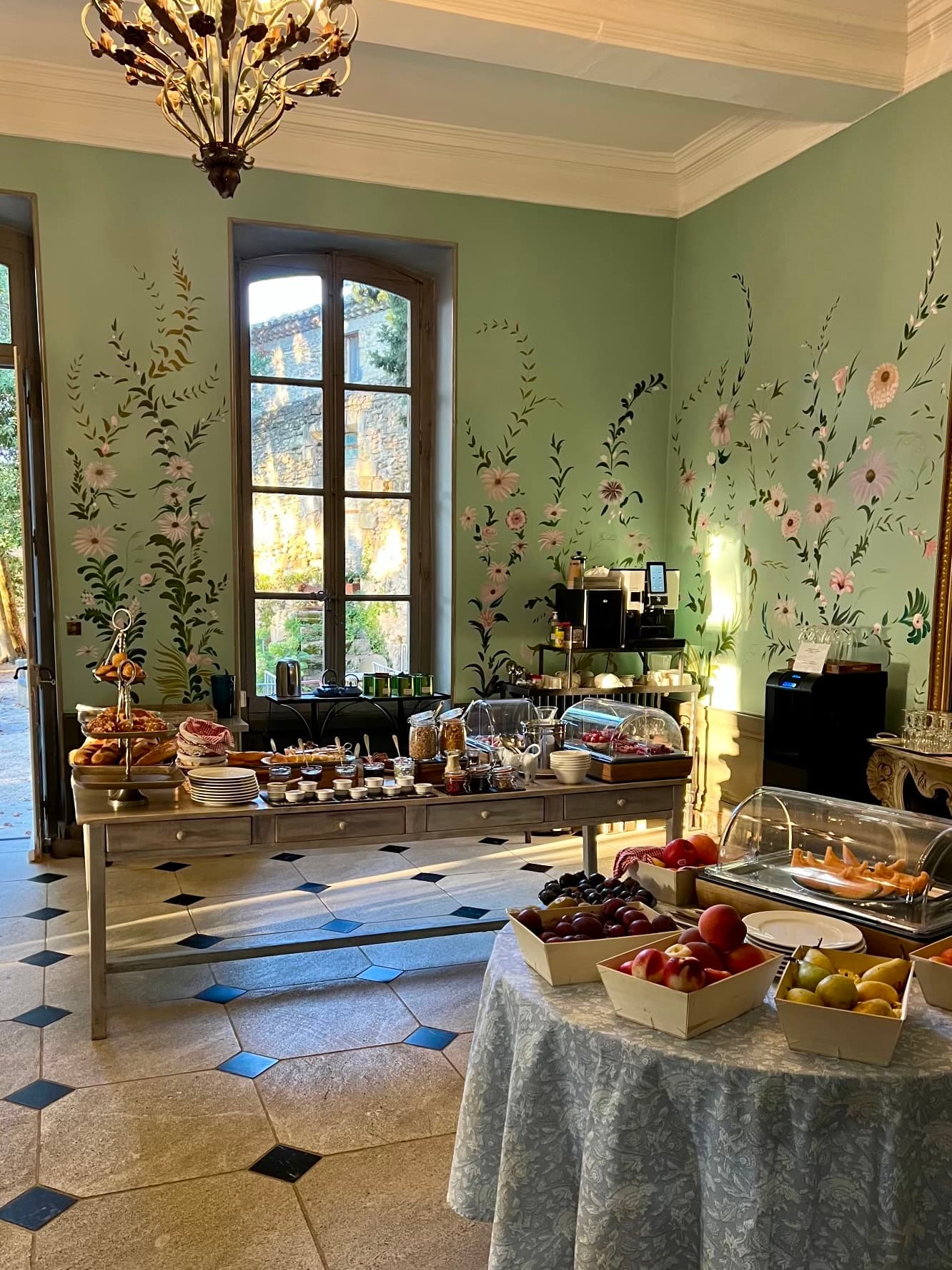 Breakfast buffet in a room with flowers painted on green walls